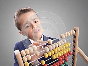 Young boy accountant businessman does calculation on a abacus