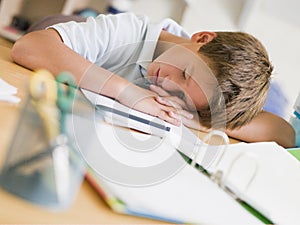 Young Boy Asleep On His Schoolbooks