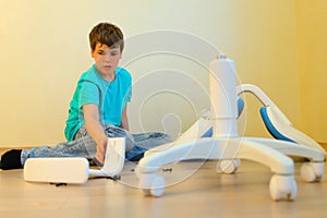 Young boy assemble parsed chair in apartment photo