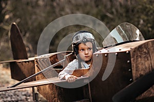 A young boy aviator in a homemade airplane in a natural landscape Authentic mood of the picture. Vintage.