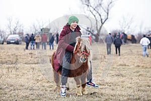 Young boy is bareback riding a pony before an Epiphany celebration horse race