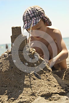 Young boy on beach making sandcastle