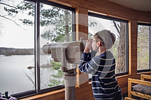 Young boy bird watching through scope.