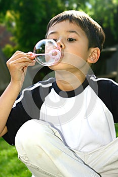 Young boy blowing bubble