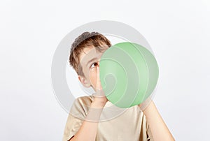 Young boy blowing a slime toy as if it would be a balloon photo