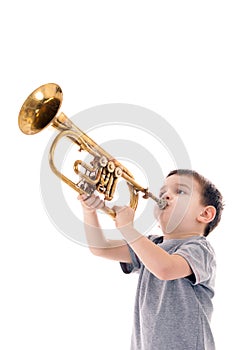 Young boy blowing into a trumpet