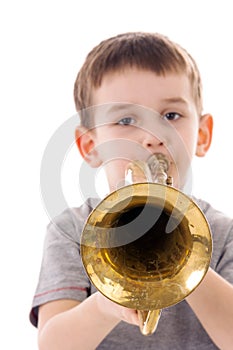 Young boy blowing into a trumpet