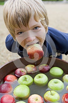 Young boy bobbing for apples