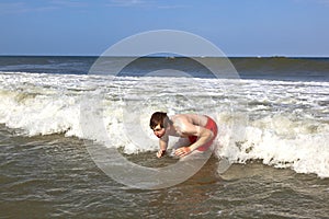 Young boy is body surfing in the waves