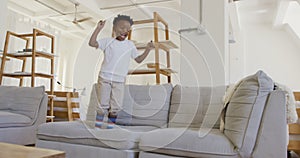 Young boy bouncing on couch