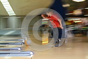 Young boy bowling at club having his first strike