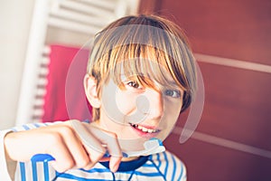Young boy brushing his teeth on waking up in the bathroom New day of everyday life