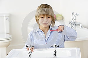 Young Boy Brushing Teeth at Sink