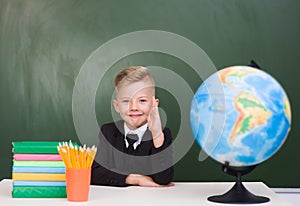 Young boy in a business suit raising hand knowing the answer to the question photo