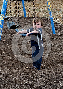 Young boy cant climb on tall swing