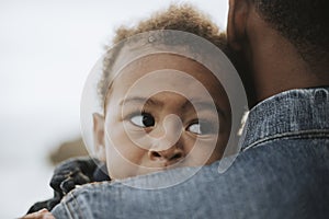 Young boy carried by his dad outdoors