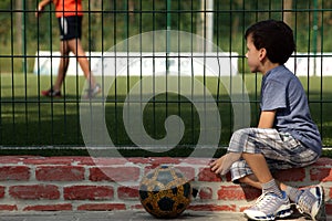 Young boy child watching football game for grid
