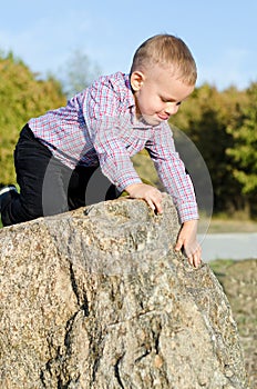 Young boy clambering on rocks