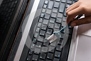 Young boy cleaning laptop computer