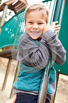 Young Boy On Climbing Frame In Playground