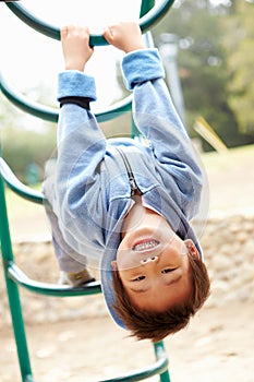 Young Boy On Climbing Frame In Playground