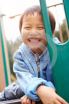 Young Boy On Climbing Frame In Playground