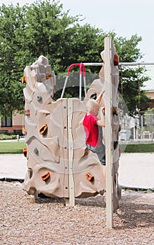 Young Boy Climbing a Rock Wall