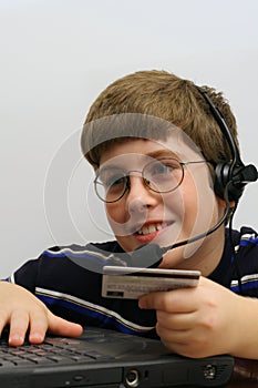 Young boy on computer using credit card