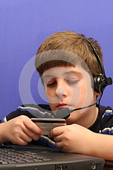 Young boy on computer using credit card blue