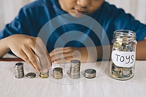 Young boy counting his coins/savings to buy dream toys.