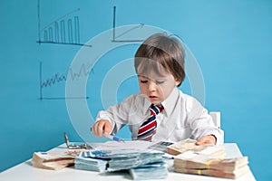 Young boy, counting money, taking notes