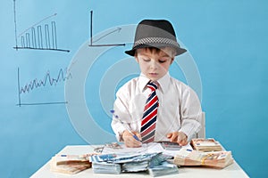 Young boy, counting money and taking notes