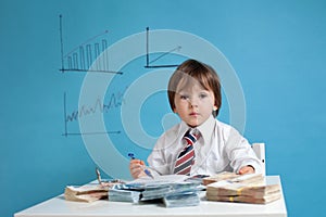 Young boy, counting money and taking notes