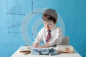 Young boy, counting money and taking notes