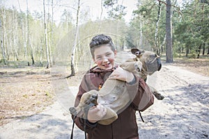 Young boy crouched down talking to his dog