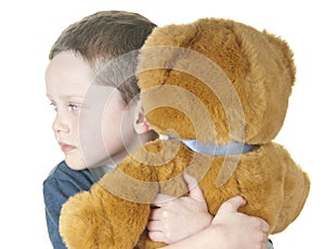 Young boy cuddling bear