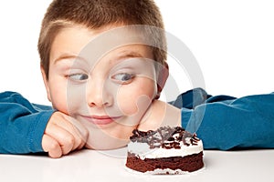 Young boy deciding to eat a dessert