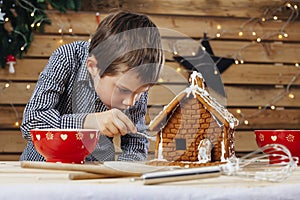 Young boy decorating gingerbread house