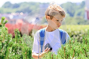 Young boy with a digital camera taking pictures outdoor