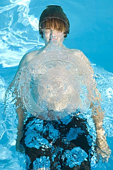 Young boy diving in pool