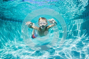 Young Boy Diving Underwater in Swimming Pool