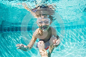 Young Boy Diving Underwater in Swimming Pool