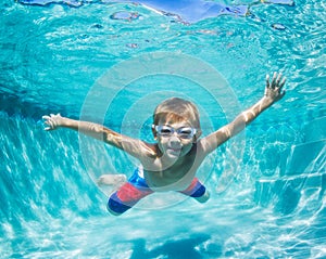 Young Boy Diving Underwater in Swimming Pool