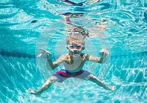 Young Boy Diving Underwater in Swimming Pool