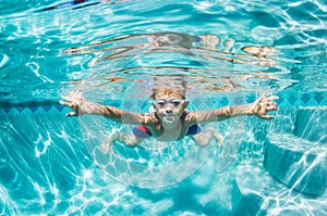 Young Boy Diving Underwater in Swimming Pool