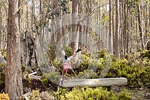 Young boy does a cartwheel on a tree trunk