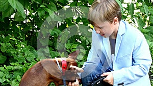 Young boy with dog in green park background.