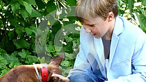 Young boy with dog in green park background.