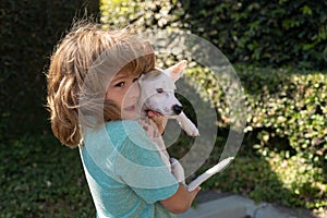 Young boy and dog hug together. Happy boy hugging his pet. Child lovingly embraces his pet dog.