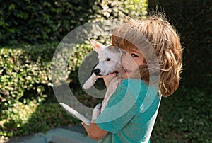 Young boy and dog hug together. Happy boy hugging his pet. Child lovingly embraces his pet dog.